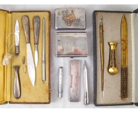 A mixed lot comprising two boxed dip pen and seal sets, two cigarette cases, a white metal comb and two pencils.
