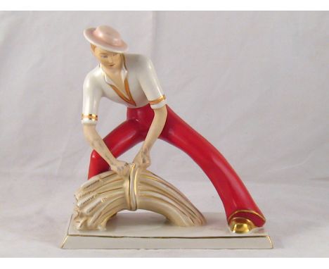 A Royal Dux heroic style ceramic figure of a reaper tying a sheaf of wheat, incised signature Elly Strobach. Ht. 20cm. 