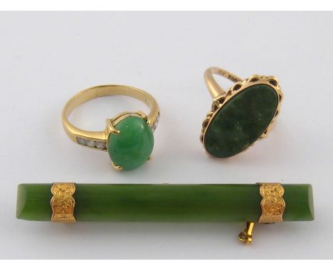 A mixed lot comprising a yellow metal (tests 14 carat gold) jade bar brooch, 58mm long, together with two jade rings, one mar