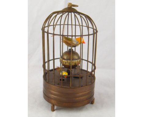 A bird in cage table clock with two moving birds and central rotating globe. 19cm. high. 