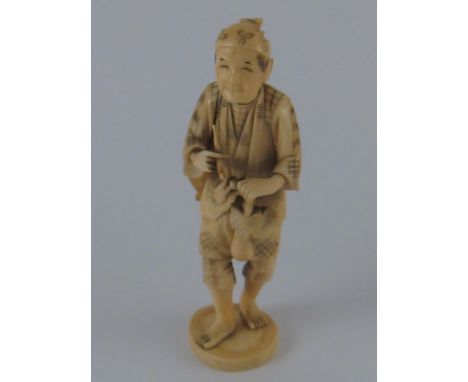 A Japanese sectional bone carving of a peasant with pipe, fruit and basket. ht.14cm. 