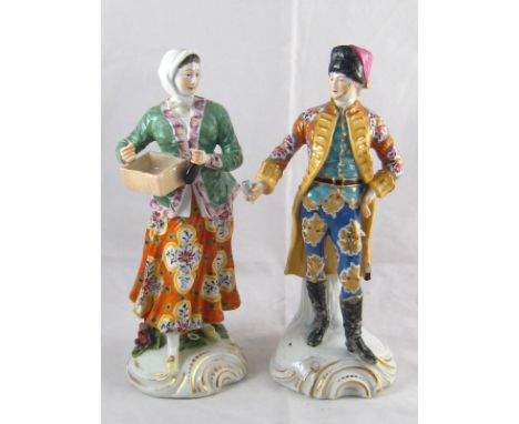 A pair of ceramic figures, the gentleman wearing a fur hat, the woman with basket and bottle. Gold anchor mark to each. (AF).