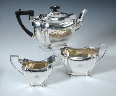 An Edwardian silver three piece tea set, by Williams (Birmingham) Ltd, Birmingham 1904, comprising:- a teapot of lobed octago