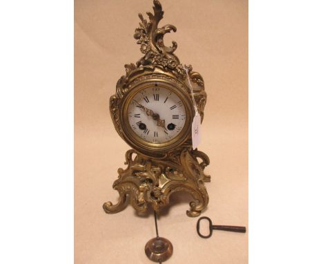 A late 19th/early 20th century French ormolu mantel clock, pendulum and key, 29cm high  
