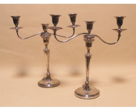 A pair of George III silver candlesticks, Sheffield assay each with an Old Sheffield plate three light branch,  