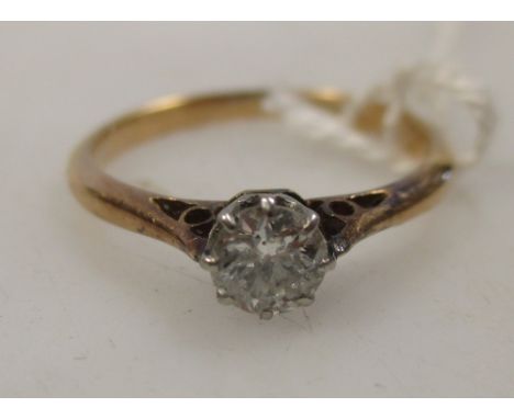 A diamond solitaire ring, the round brilliant cut diamond, estimated 0.3cts, claw set in white metal to a yellow metal band s