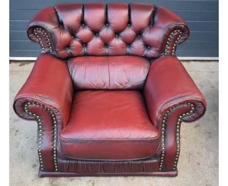 Red oxblood leather Chesterfield-style button-back armchair with metal beading, 110x96x92cm tall.  In good condition with som