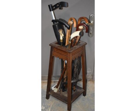 1930s wooden hall stick stand together with a range of walking sticks, to include country interest, and a metal detector (Qty
