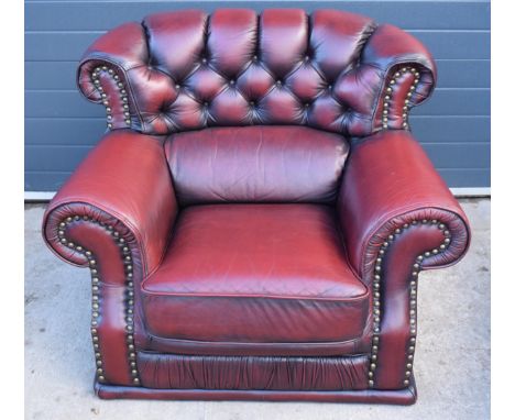 Red oxblood leather Chesterfield-style button-back armchair with metal beading, 110x96x92cm tall.  In good condition with som