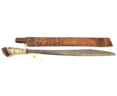 A Borneo headhunter’s sword, swollen blade 21”, with non original horn grip, in raffia bound wooden scabbard. Basically GC   