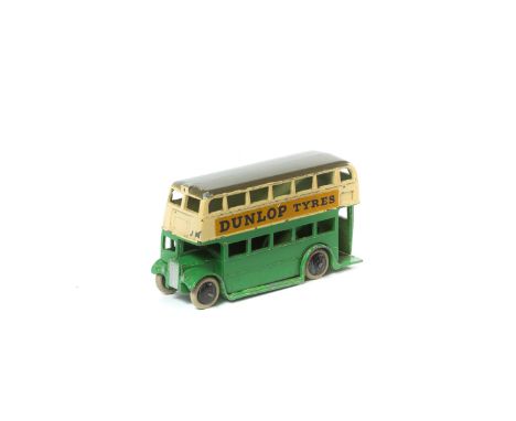 A scarce 1930s Dinky Toys AEC Double Deck Bus (29c). Green lower body, cream upper with a dark grey roof, 'DUNLOP TYRES' adve