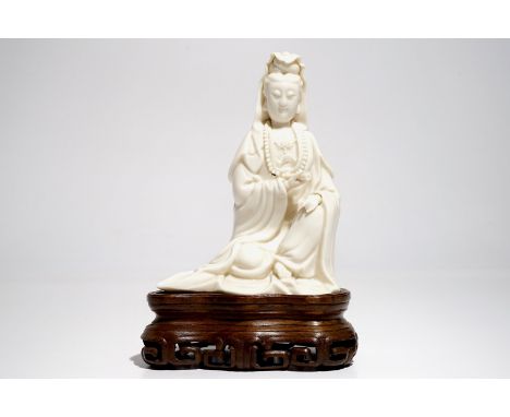 A Chinese Dehua blanc de Chine Guanyin on wooden stand, Kangxi H.: 22,5 cm (incl. stand) H.: 18 cm (excl. stand)