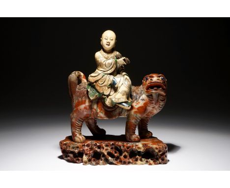 A Chinese soapstone figure of the immortal Vajraputra on a Buddhist lion, Kangxi/Qianlong H.: 25 cm - L.: 20,5 cm - W.: 10,5 