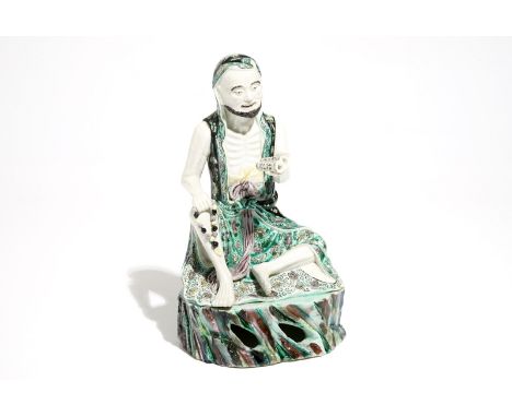 A Chinese verte biscuit model of a luohan with a scroll, Kangxi H.: 20 cm