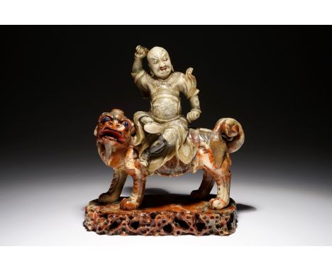 A Chinese soapstone figure of the immortal Vaishravana on a Buddhist lion, Kangxi/Qianlong H.: 25 cm - L.: 21 cm - W.: 9,5 cm