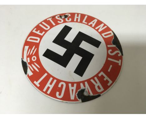 A small German WW2 circular enamel plaque of a swastika, with Deutschland text. Diameter approx 15cm.