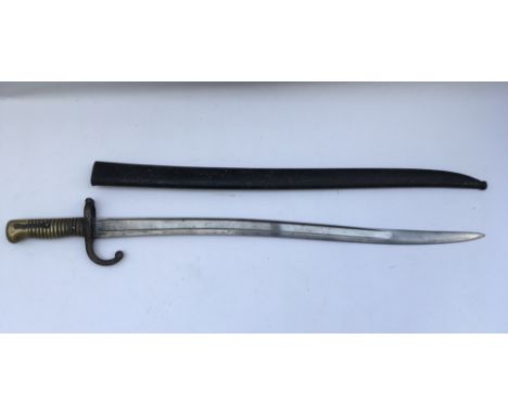 A French bayonet, possibly 19th Century with engraved blade spine. Scabbard included. Blade length approx 57cm, total 70cm.