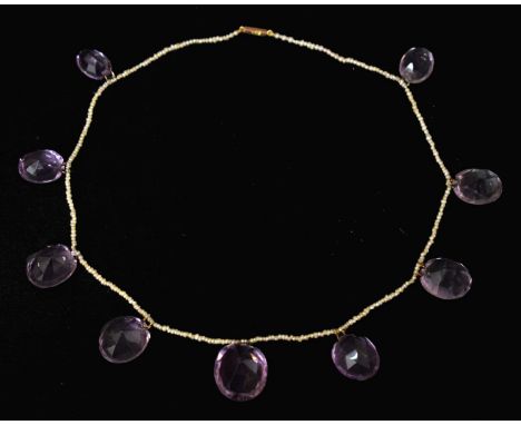 Late Victorian amethyst and seed pearl 9ct rose gold necklace, nine graduated oval mixed cut amethyst suspended from the seed