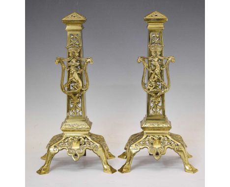 Pair of brass fire dogs or andirons, each of open column form applied with a Coat of Arms (a crowned shield with seated greyh