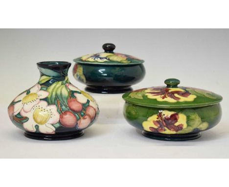 Moorcroft - Two covered bowls in the 'Hibiscus' pattern and a vase of squat form in the 'Cherries' pattern designed by Emma B