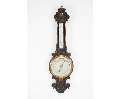 Edwardian carved oak aneroid barometer, the 8-inch silvered dial reading from 26 to 31 inches of pressure, signed G. Farran, 