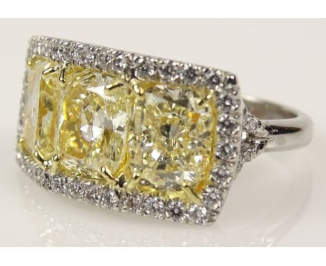 Lady's Stunning 6.50 Carat Cushion Cut Three Stone Fancy Intense Yellow Diamond, Platinum and 18 Karat Yellow Gold Ring accen