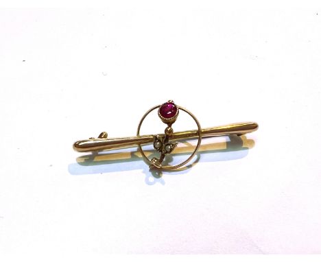 An Edwardian yellow metal bar brooch with seed pearl and ruby flower, stamped 9ct. 2 gm 
