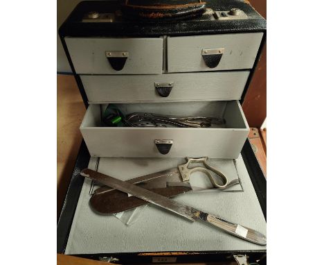 A 20th century doctor's case with an amputation saw and other surgical tools 