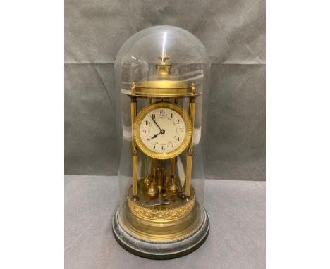 Antique anniversary clock with enamel face under glass dome