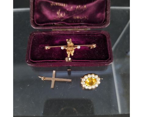 A yellow metal bar brooch with bear model set with rubies and seed pearls, a small 9ct gold cross plus a small topaz and pear