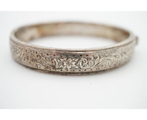 An Elizabeth II silver hinged bangle, with engraved foliate decoration, bearing the name 'Elspeth' to the interior, 16.1g