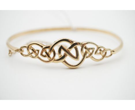 A 9ct gold hinged bangle of Celtic influence, 9.9g