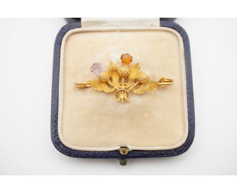 A 9ct gold, amethyst and citrine Scottish stock pin / bar brooch, naturalistically modelled as three thistles, retailed by Je