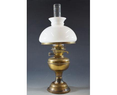 A brass oil lamp with milk glass shade