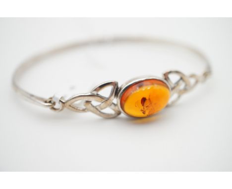 A contemporary copal amber and white-metal bangle of Celtic influence, in original box, 9.4g