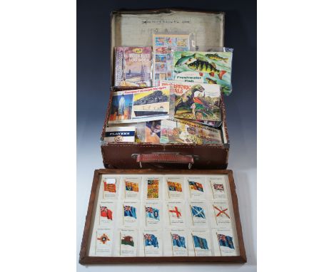 A vintage travel case containing a collection of tea and cigarette cards and completed albums, including Brooke Bond's "The R