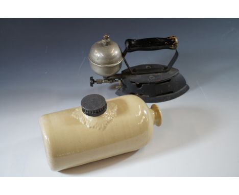 A vintage gas iron and stoneware hot water bottle