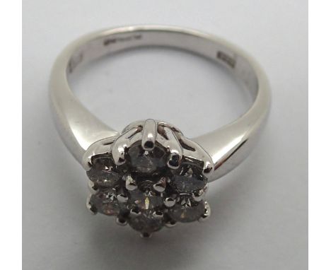 An 18ct white gold diamond flower head cluster ring totaling .75cts 4.9g, size K