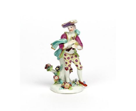 A Derby figure of a piping shepherd boy  c.1760, standing on a low pad base applied with flowers, his bagpipes tucked under h