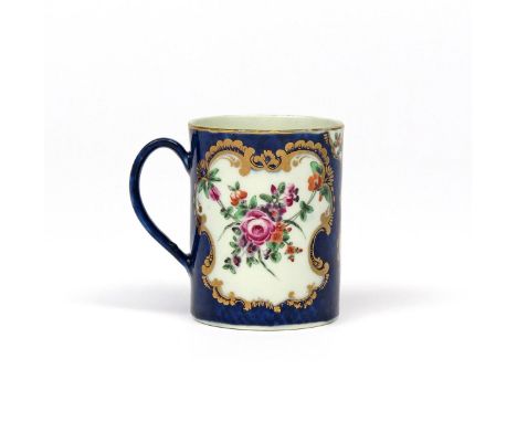 A small Worcester mug  c.1770-75, the cylindrical form painted with shaped panels of polychrome flowers reserved on a blue sc