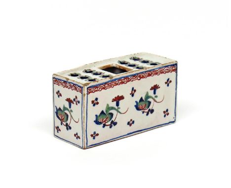 A small delftware polychrome flower brick  c.1730-50, of rectangular form, painted in red, green and blue enamels with styliz