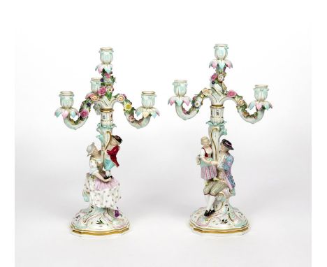 A pair of Meissen figural candelabra  19th century, each modelled with a gentleman and his companion seated with a child stan