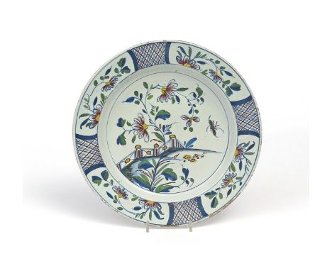 A Bristol delftware charger  c.1760, painted in polychrome enamels with an insect flying beside flowering branches and an orn