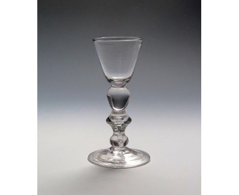 A light baluster cordial or small wine glass  c.1725, the round funnel bowl supported on an egg knop above a bladed knop encl