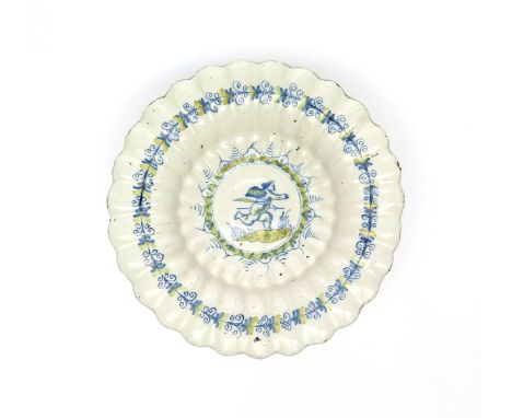 A Continental tin-glazed lobed dish  late 17th/early 18th century, painted in blue and yellow with a winged putto running wit