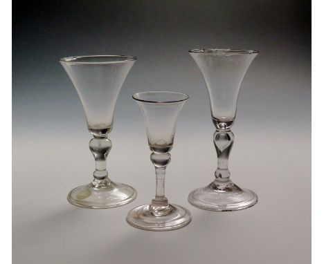 Two light baluster wine glasses  c.1730, with bell bowls raised on inverted baluster stems enclosing tears above folded conic