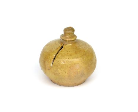 A small North Devon pottery moneybox  17th/18th century, the squat globular form partially decorated in a pale yellow glaze b