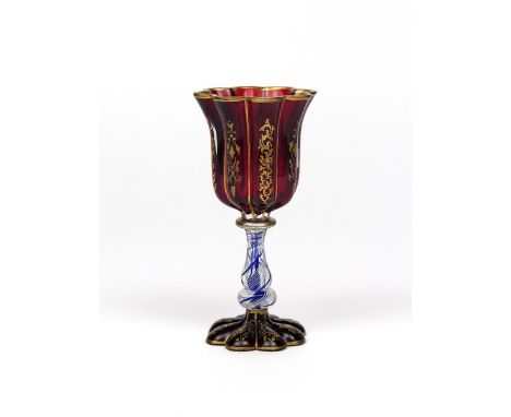 A Bohemian glass goblet  19th century, the fluted ruby glass bowl gilded with foliate scrolls, raised on a colour twist stem 