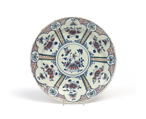 A Bristol delftware charger  c.1730-40, painted in red, green and blue with six shaped panels of simple flower sprigs around 