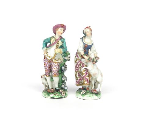 A pair of Chelsea figures of a shepherd and shepherdess  c.1760-65, he leaning on a flowering stump with a hand on one hip, a